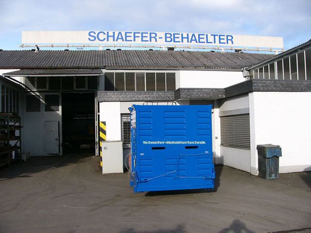 Blau lackierter Sonderbehälter mit Deckelklappen vor der Werkshalle