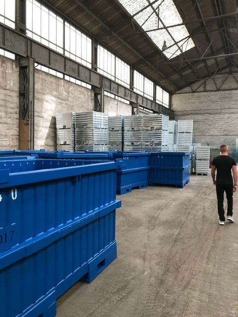 Sonderbehälter, blau lackiert – im Hintergrund verzinkte RCA-Behälter mit Ablasshahn